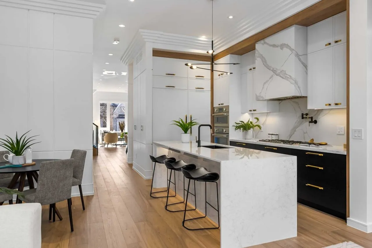 Luxury modern kitchen renovation with white cabinets, marble waterfall island, wood beam ceiling, and open floor plan